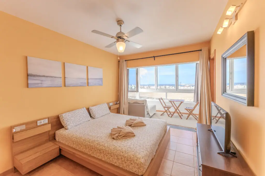 Suite principal de Villa DONPI con cama doble, terraza y vistas al mar en Playa Blanca, Lanzarote