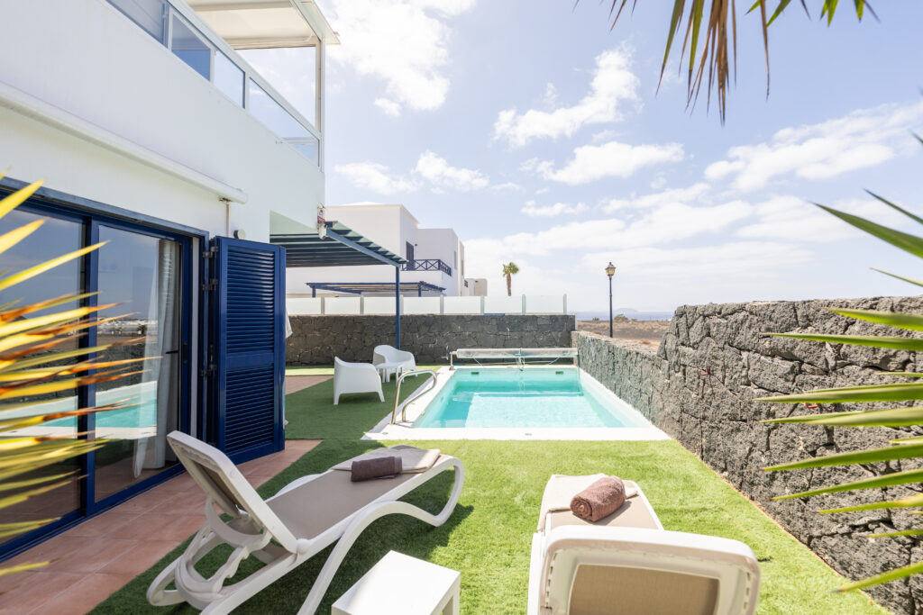 Piscina al aire libre con jardin para tomar el sol en villa dompi.