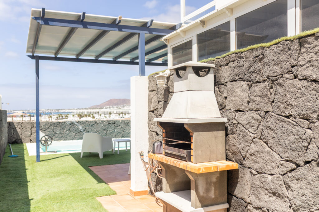 Jardin amplio con parrilla para hacer barbacoa.