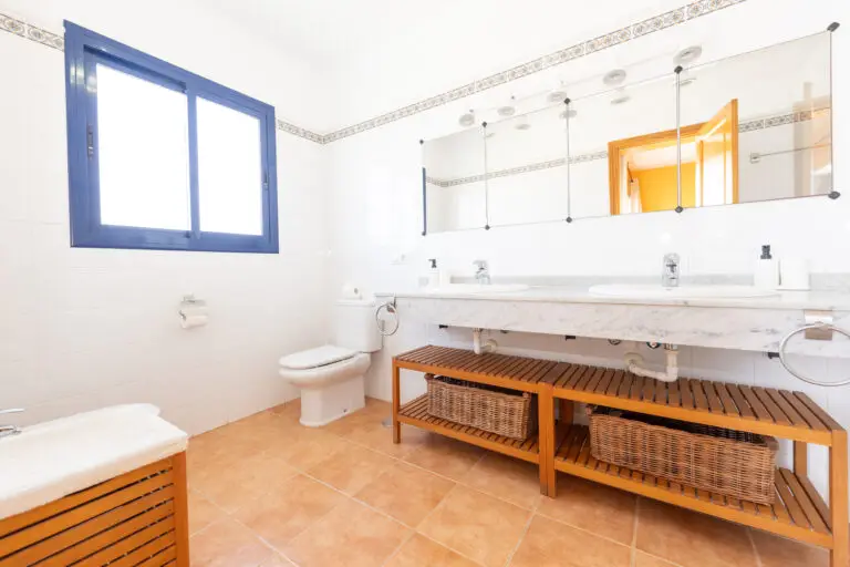 Baño moderno con ducha acristalada y acabados en mármol en suite de villa dompi.