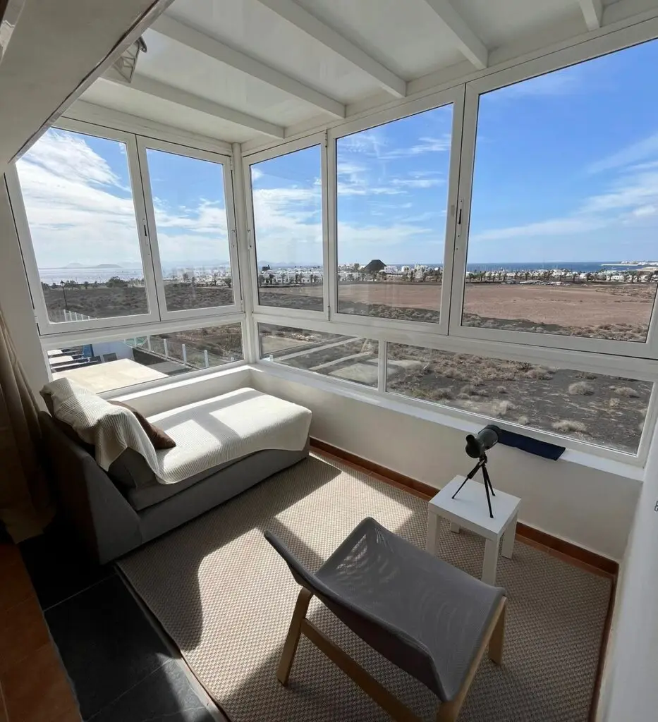 Se ve una terraza cubierta de la suite principal de Villa Dompi con vistas a la urbanizacion y al mar.